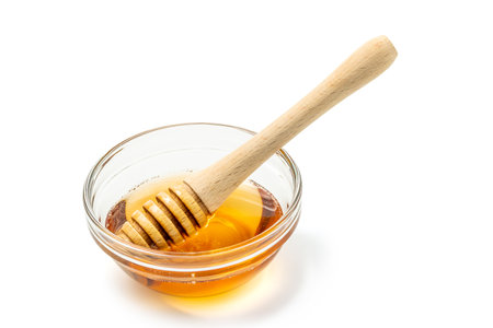 Honey bowl and dipper isolated on white background as package design element. Clipping path includedの写真素材