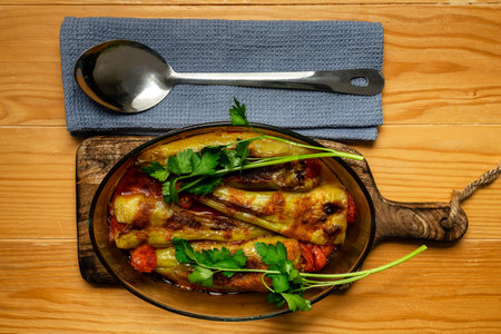 Stuffed peppers baked with tomato sauce in an oval refractory glass dishの写真素材