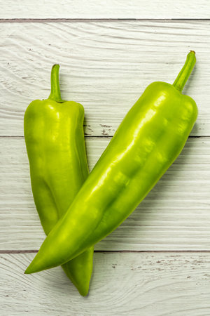 Green peppers on a white wooden table backgroundの写真素材