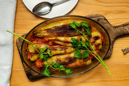 Stuffed peppers baked with tomato sauce in an oval refractory glass dishの写真素材