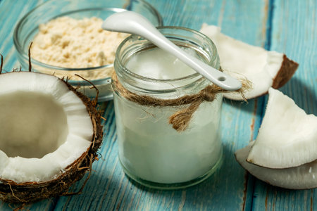 Coconut oil in jar, coconut protein in bowl and fresh coconuts on old vlue wooden tableの写真素材