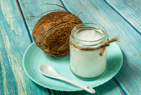 Coconut oil and fresh coconuts on old vlue wooden tableの写真素材