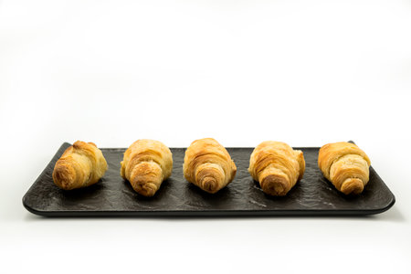Traditional rolled dough called Kiflice served on black plate and white backgroundの写真素材