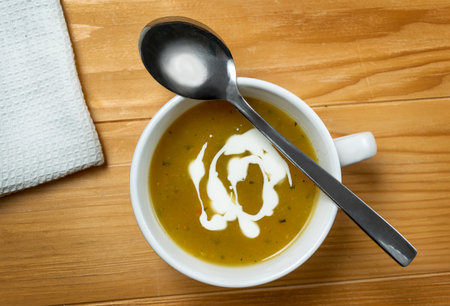 Homemade vegetarian zucchini soup with blue cheese in a white bowl on an old, wooden, brown table. Top Viewの写真素材