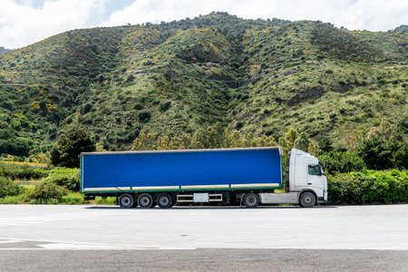 Cargo Truck. Truck transportation, import, export logistic industrial with parking lot and hills in the backgroundの写真素材