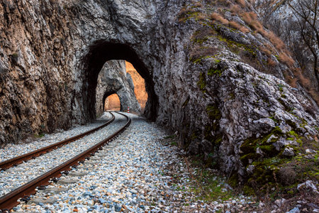 Old railway passing through short tunnels in picturesque rural sceneryの写真素材
