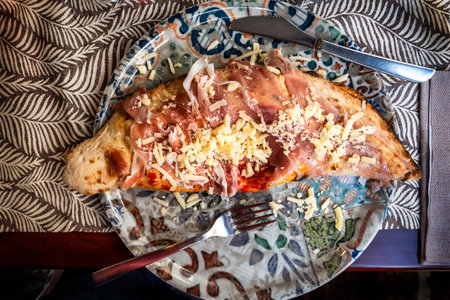 Closed calzone pizza on a plate in the Italian restaurant tableの写真素材