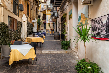 Agrigento, Sicily, Italy - May 19, 2023: Cityscape with old historical buildings, narrow street and restaurants tables with colorful ceramic decorations in Agrigento, Sicilyのeditorial素材