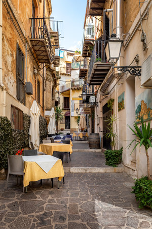 Agrigento, Sicily, Italy - May 19, 2023: Cityscape with old historical buildings, narrow street and restaurants tables with colorful ceramic decorations in Agrigento, Sicilyのeditorial素材