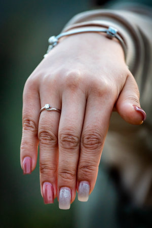 Engagement ring on young womans hand. Selective focus with blurred background