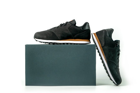 Pair of Stylis New Black roughout Leather Sneakers and a box isolated over white Background. Black tennis shoesの写真素材