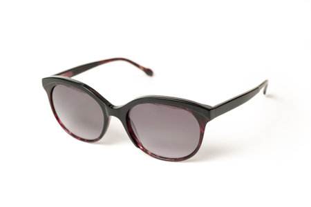 Black elegant female Sunglasses with purple details isolated on white background. Sun glasses summer accessories as design element.の写真素材