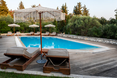 Swimming pool and beds for relaxing in summer. Swimming pool in the nature among greenery.の写真素材