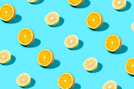 Trendy Summer food pattern made with yellow lemon and orange slice on bright light blue background. Minimal summer concept.の写真素材