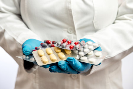 Doctors Hands in blue protective gloves holding a stack of many different pills. Medicine drugsの写真素材