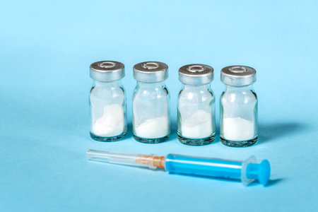 Syringe and needle with glass medical ampoule vials for injection. Medicine is dry white drug penicillin powder or liquid with of aqueous solution in ampullaの写真素材
