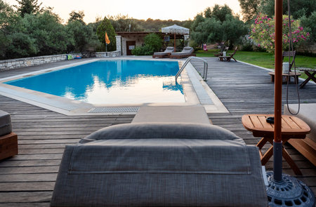 Swimming pool and beds for relaxing in summer. Swimming pool in the nature among greenery.の写真素材