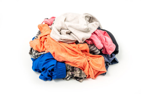 Textile ready to recycle, isolated on white background. Heap of used colorful clothes for recyclingの写真素材