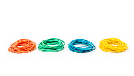 Stacks of different rubber bands on white background. Red, green, blue and yellow rubber bandsの写真素材