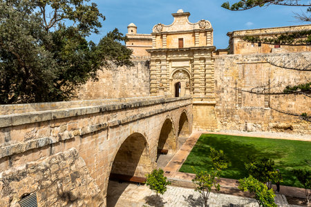 Entrance bridge and gate to Mdina, a fortified medieval city in the Northern Region of Malta.の写真素材