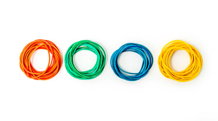 Stacks of different rubber bands on white background. Red, green, blue and yellow rubber bandsの写真素材