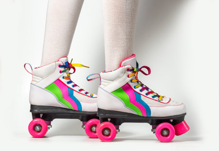 Portrait of woman legs wearing four-wheeled roller blades with colorfull laces on white backgroundの写真素材