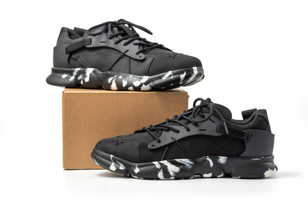 Black leather shoes with cardboard box isolated on white background. A pair of modern stylish black sneakers.の写真素材