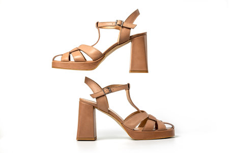 Studio photo of a pair of light brown suede female sandals on white backgroundの写真素材
