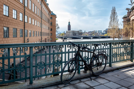 View of Stockholm City Hall and Stream's castle from Stallbron Bridge, with a bicycle docked by the bridge railingの写真素材