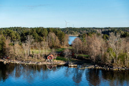 Rocky coast of Stockholm archipelago in Baltic sea with traditional white and red houses at sunny spring evening scenery.の写真素材