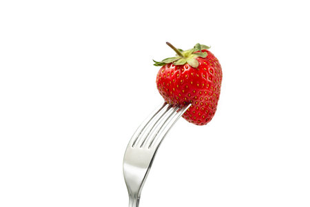 Strawberry on a fork isolated on white backgroundの写真素材