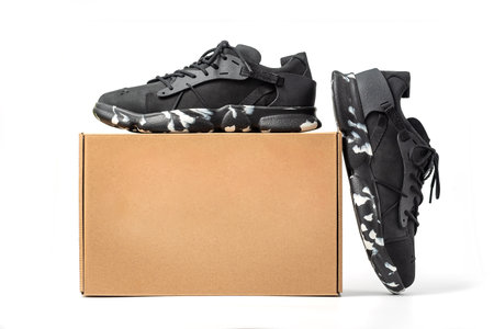 Black leather shoes with cardboard box isolated on white background. A pair of modern stylish black sneakers.の写真素材