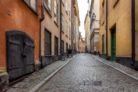 Sweden quaint cobblestone street in picturesque Gamla Stan, Stockholm's oldest neighborhood. Parked bicycles lean against the colorful plaster buildings.の写真素材