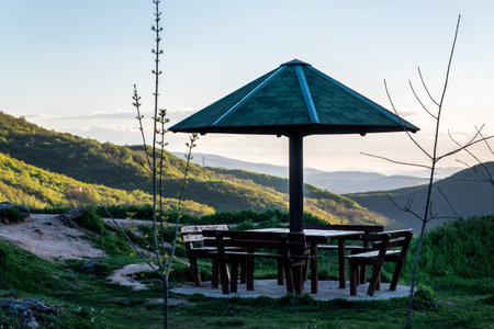 Table and benches in the mountain with a canopy as resting place from the rain, a place to relax in natureの写真素材