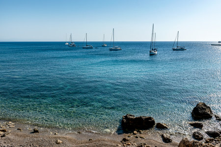 Sailboats at sunrise in the Mediterranean Sea off the coast of Mandraki harbor. Rhodes Island. Greeceの写真素材