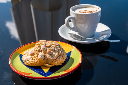 Almond Cookies served in colorful plate with a cup of coffee. A delightful pair of almond cookies, tasty treats combine crunchy textures with sweet flavors, ideal for any occasionの写真素材