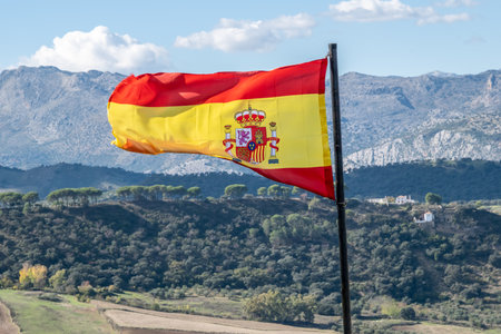 Spanish flag flying over Ronda in Spain. Red and Yellow flag of Spain flying over Ronda in Andalusia on the Costa del Solの写真素材