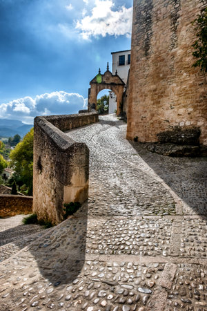 Ronda, Main entrance to city in the 17th century, Arch of Philip V related to Old Bridge, cobblestone street province of Malaga Spainの写真素材