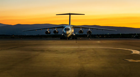Military cargo aircraft. Large cargo aeroplane landed at the airport on a beautiful sunsetの写真素材