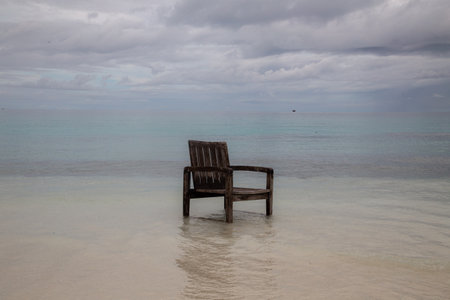 Wooden chair in the water on the beach of the Caribbean seaの写真素材