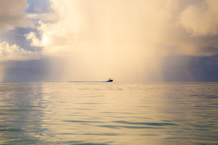 Beautiful seascape with a boat on the sea at sunsetの写真素材