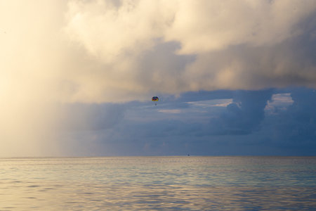 Parasailing on the sea at sunset, cloudy sky background.の写真素材