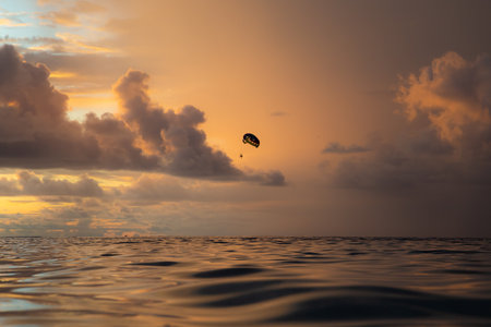 Parachutist in the sea at sunset in the Maldivesの写真素材