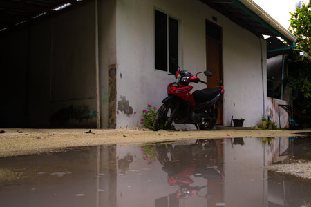 Rear view of a motorbike parked in the middle of a flooded area.の写真素材