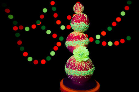 Neon UV photography bright colorful wedding cake glows fluorescent colors on a dark background in the rays of ultravioletの写真素材