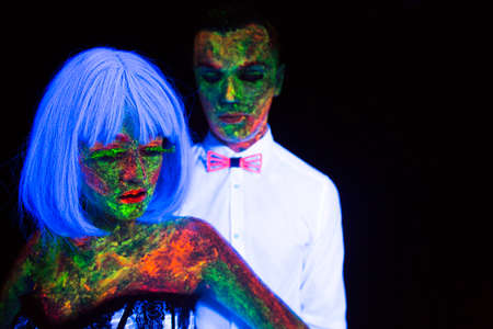 Neon photography in the rays of the ultraviolet couple in love guy and girl bride with the groom at the wedding UV radiation posing vogue styleの写真素材