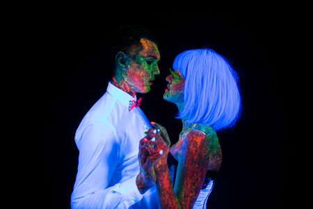 Neon photography bright colorful on a dark background in the rays of ultraviolet steam in love guy and girl bride with groom at a wedding first wedding dance UVの写真素材
