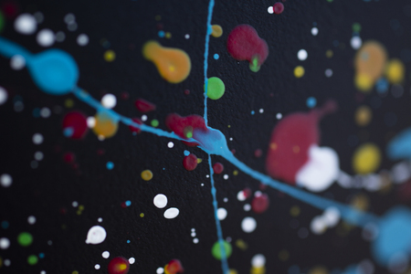bright color paint stains and drops on a dark background abstract pattern texture background macro shotの写真素材
