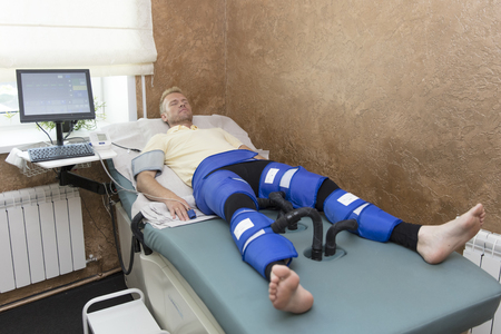 Pressotherapy machine on man in medical spa center. Cosmetic medicine devicesの写真素材