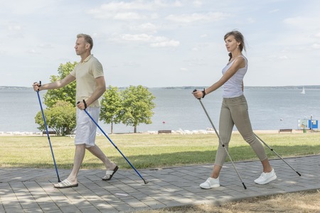 Young family couple hiking in the nature nordic walkingの写真素材